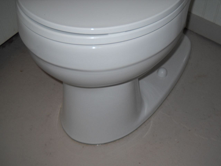Caulk or grout around toilet base